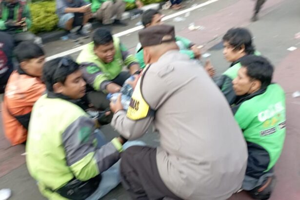 polisi membagi bagikan air mineral kepda ojol yang berdemo di patung kuda jakarta pusat selasa 2052025 siang 1747739142470 169