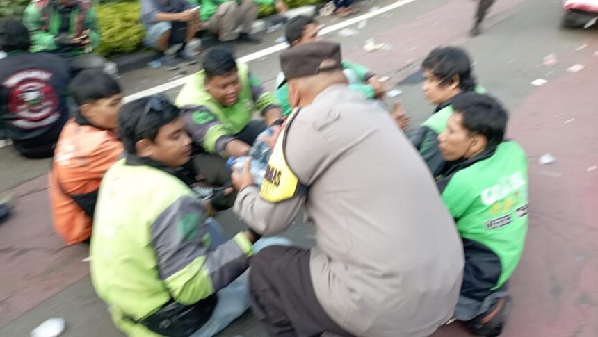 polisi membagi bagikan air mineral kepda ojol yang berdemo di patung kuda jakarta pusat selasa 2052025 siang 1747739142470 169